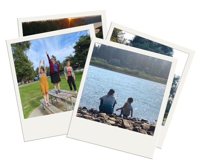 Polaroids of two photos: one with three adults in the same park setting. Two are standing on opposite benches of a picnic table while the third is standing on the top of the table. This person is holding a twig, pointing their arm and the twig directly up to the sky. One on the bench is lifting both arms above their head in a tree like pose. The second picture is of a riverside setting. Two people, an adult and a child are looking out towards a river that cuts across the photo. There is a shore with riverfront homes and lots of trees in the distance and lots of grey river rocks in the foreground.